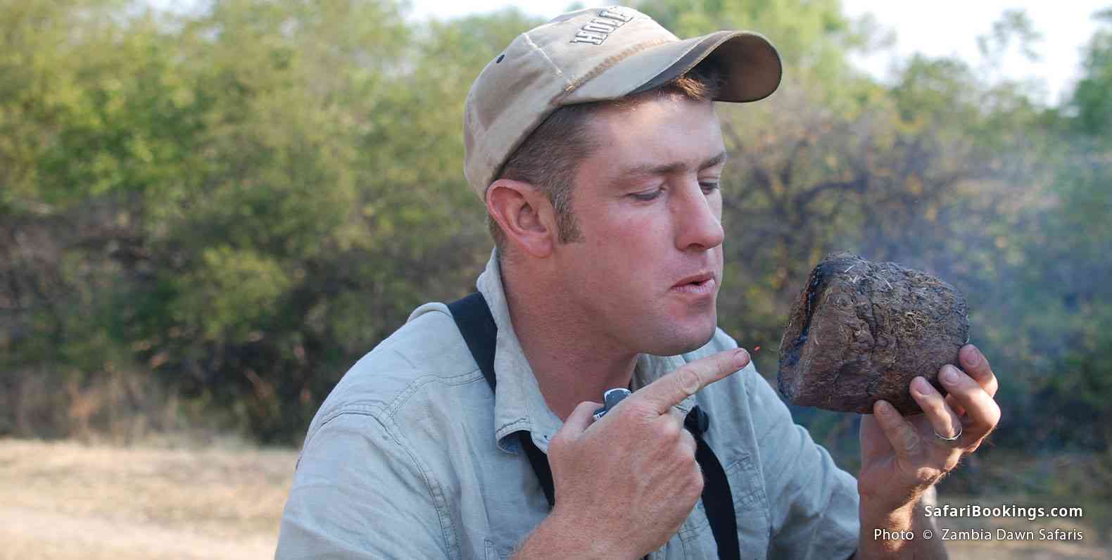 Guide David burning elephant dung