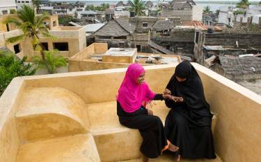 Swahili women painting hands with henna