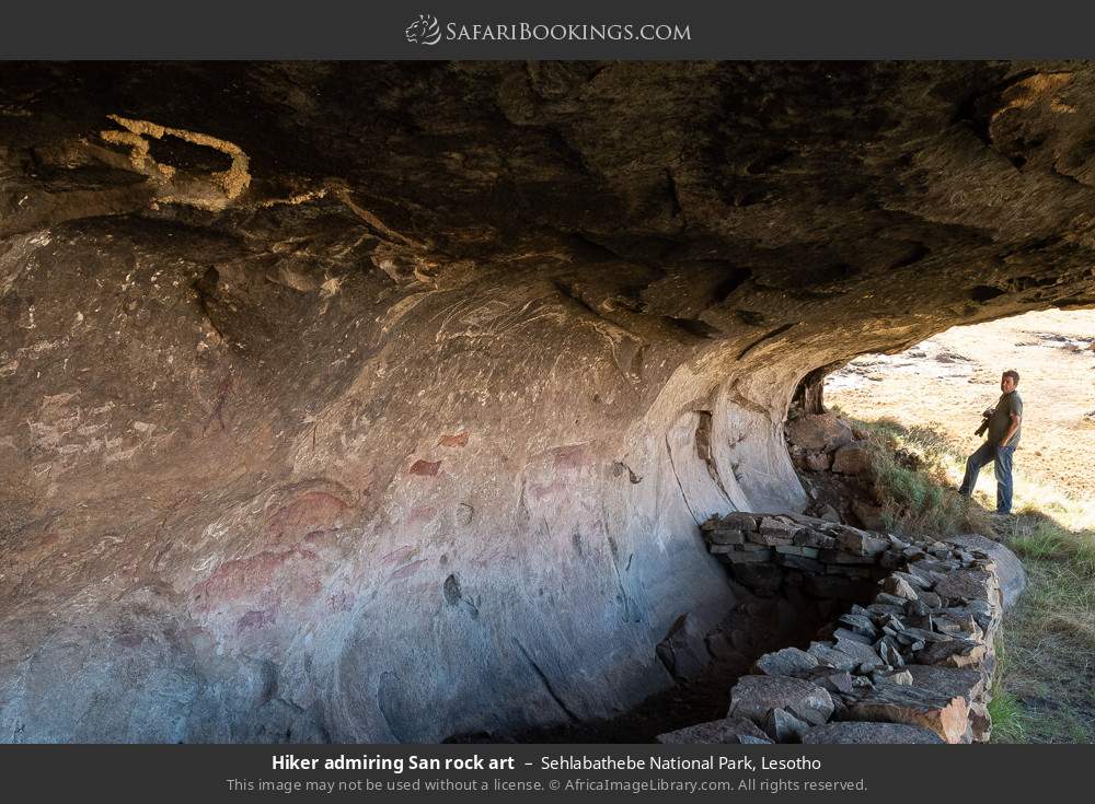 Hiker admiring San rock art in Sehlabathebe National Park, Lesotho