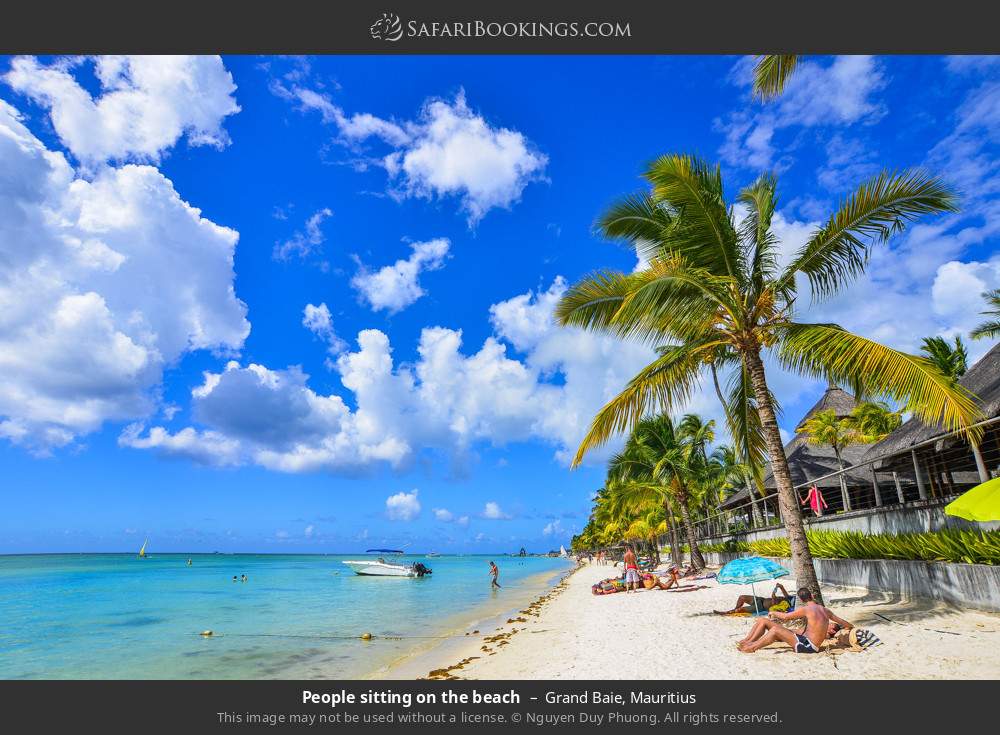 People sitting on Grand Baie Beach in Grand Baie, Mauritius