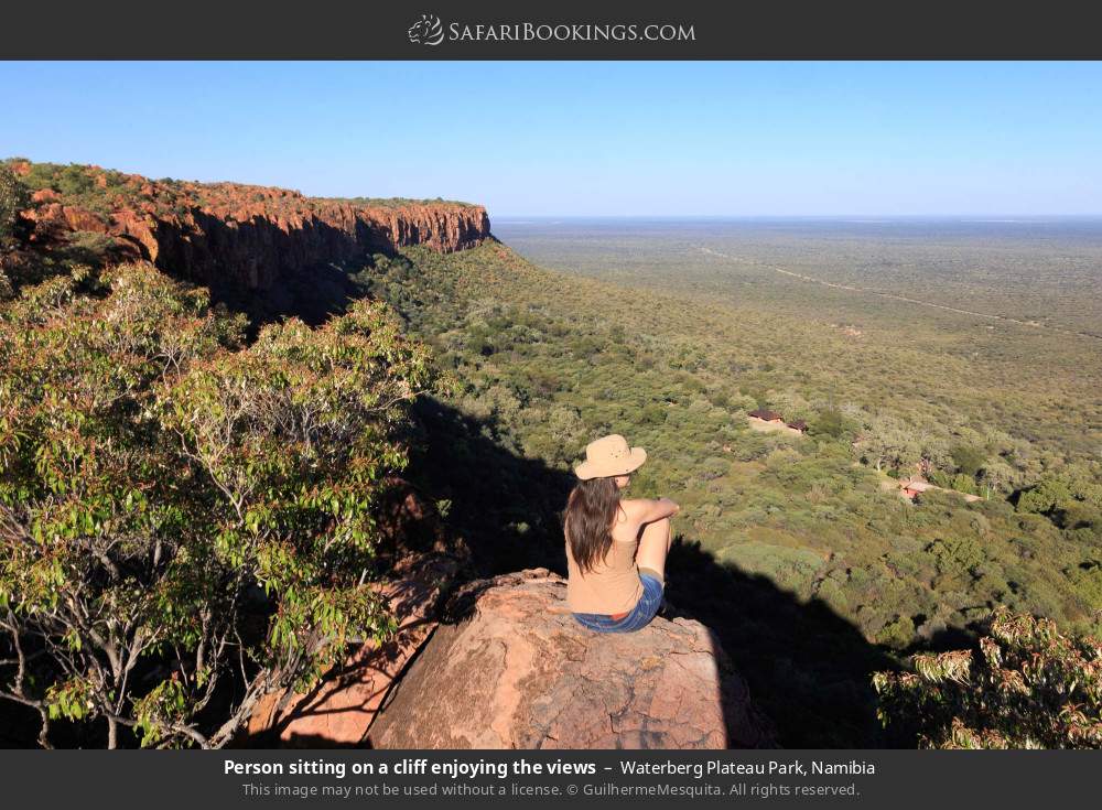 Person sitting on a cliff on Waterberg Plateau enjoying the views in Waterberg Plateau Park, Namibia