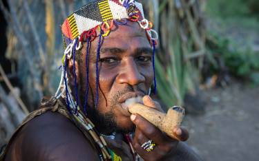 Hadzabe bushman smoking a traditional pipe