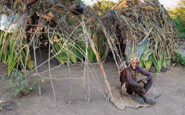 Hadzabe man sitting in front of his hut