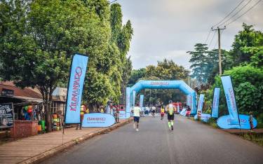 Runners approaching a water table at the Kilimanjaro Marathon