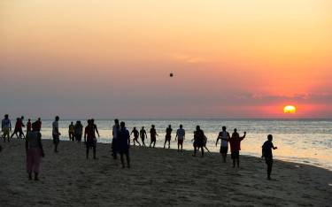 Soccer game on the beach at sunset