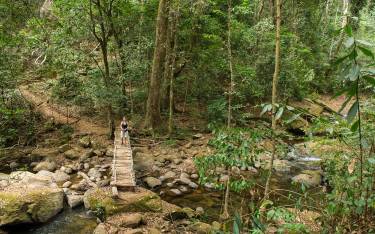 Hiker crossing the Sanje River