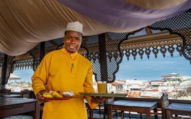 Waiter serving breakfast at a rooftop restaurant