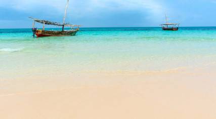 Small dhows on the azure blue waters surrounding the island