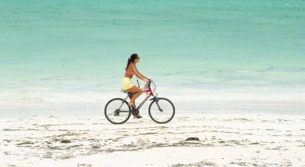 Woman cycling on the beach