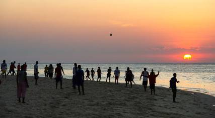 Soccer game on the beach at sunset