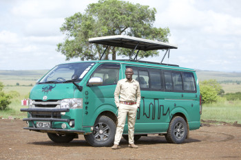 Our tour guide Dennis with our green safari van